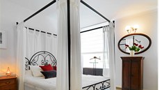 Ložnice pro hosty v provensálském stylu je vybavená kobercem v podobě přírodní...