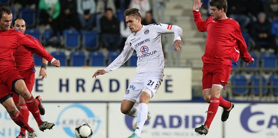 V OBLEŽENÍ. Milan Kerbr, fotbalista Slovácka (v bílém), kličkuje proti přesile