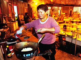 Jedna z obyvatelek Tchu-lou ve vesnice Tchien-luo-kcheng pipravuje veei.