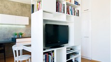 Knihovna umístná v prostoru opticky rozdluje obývací místnost na jednotlivé...