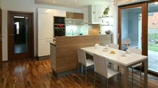 Francouzské okno za jídelním stolem vede k venkovnímu posezení a do zahrady.