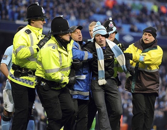 Policie a poadatelská sluba v akci bhem zápasu anglické Premier League.