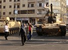 Obyvatelé Káhiry prochází kolem tank, které byly umístny ped prezidentským