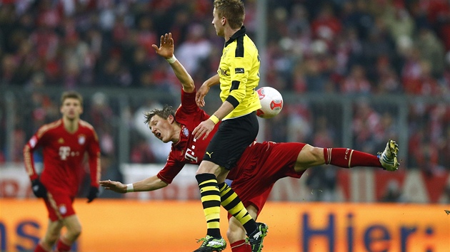 DROBN TVRK. Dortmundsk stzlk Marco Reus (ve lutm) zboural Bastiana Schweinsteigera, zlonka Bayernu.