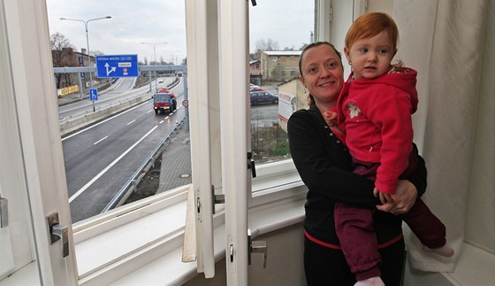 Petra Vaská s dcerkou Patricií u okna s výhledem na nový dálniční přivaděč.