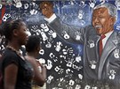 Jihoafrianky ped portrétem Nelsona Mandely na zdi v johannesburském pedmstí