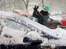 Dívka odmetá sníh ze svého auta v centru Plzn. (10. prosince  2012)