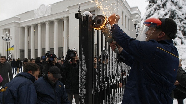 Poslanci strany Svoboda ve stedu rozezali kovov zbrany ped ukrajinskm parlamentem. (12. prosince 2012)