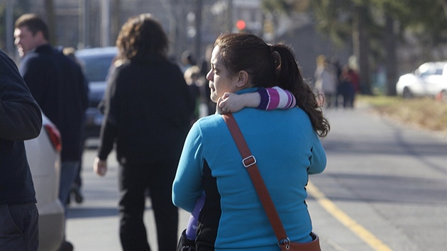 Matka po střelbě ve škole Sandy Hook chrání svoji dceru v náručí. (14. prosince 2012)