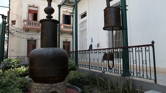 Vstupní expozice před Muzeem rumu v Santiagu de Cuba a starý přístroj na plnění lahví