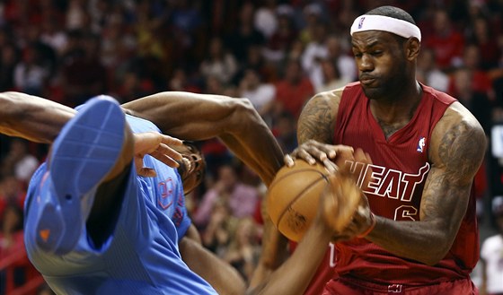 LeBron James (vpravo) z Miami a Serge Ibaka z Oklahoma City v tvrdém souboji o