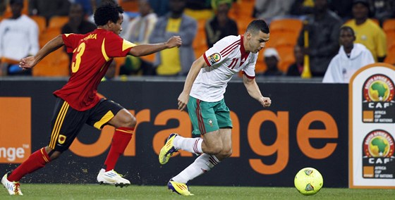 PIJDE SKLUZ? Angolský fotbalista Miguel stíhá Oussamu Assaídího z Maroka.