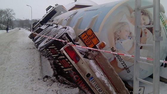 Rakouský kamion sklouzl ze zasněžené krajnice a opřel se o plot novostavby