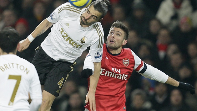 OBTAV HLAVIKA. Obrnce Chico Flores ze Swansea nepustil do ance Oliviera Girouda z Arsenalu. 