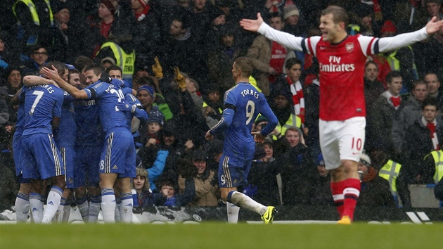 GL PO ESTI MINUTCH. Fotbalist Chelsea se raduj z trefy Juana Maty, zatmco Jack Wilshere z Arsenalu marn gestikuluje.