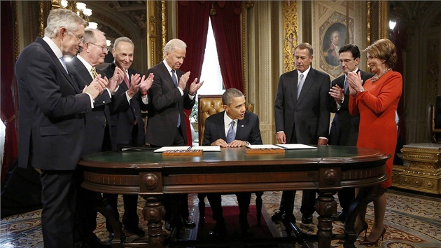 Barack Obama podepsal prvn dokumenty ve svm druhm obdob. Obklopen byl pitom vrcholnmi americkmi politiky - nejble k nmu stoj Joe Biden (vlevo) a f Snmovny reprezentant John Boehner (vpravo). Nejble k fotoapartu stoj f demokrat v Sentu Harry Reid (21. ledna 2013).