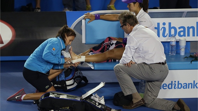 OETEN. Fyzioterapeutka oetuje kotnk anky Li Na ve finle Australian Open.
