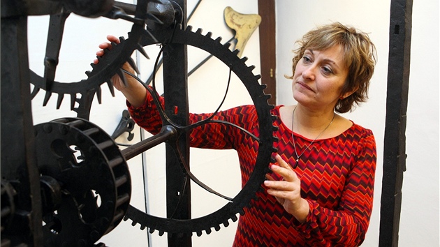 Muzejnice Ingrid Kotenová ukazuje jeden z vystavených strojů na měření času. 