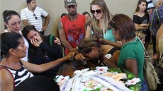 Píbuzní truchlí u rakve jedné z obtí ve sportovní hale v brazilském mst