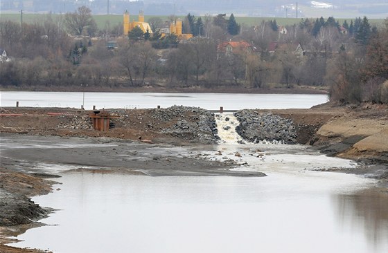 Voda protéká pes provizorní sypanou hráz rozdlující Jordán.