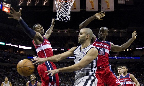 Tony Parker ze San Antonia pihrává kolem obránc z Washingtonu na volného