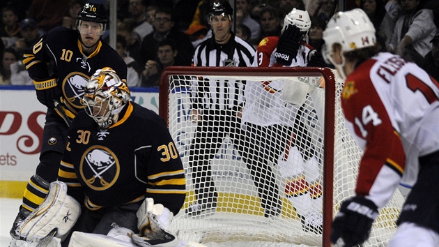 Tom Fleischmann (vpravo) z Floridy sleduje, jak si porad s pukem glman Ryan Miller z Buffala. Vlevo Christian Ehrhoff.