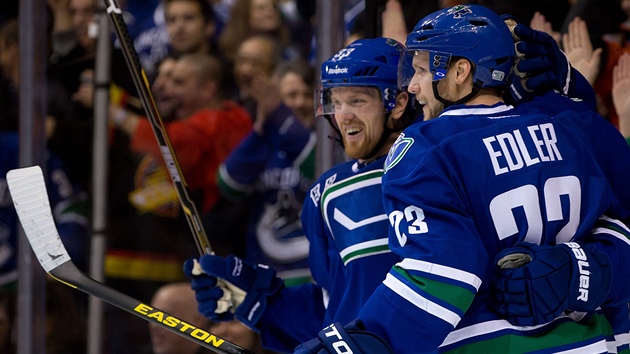 Vancouvert hokejist Alexander Edler a Henrik Sedin se raduj z glu.