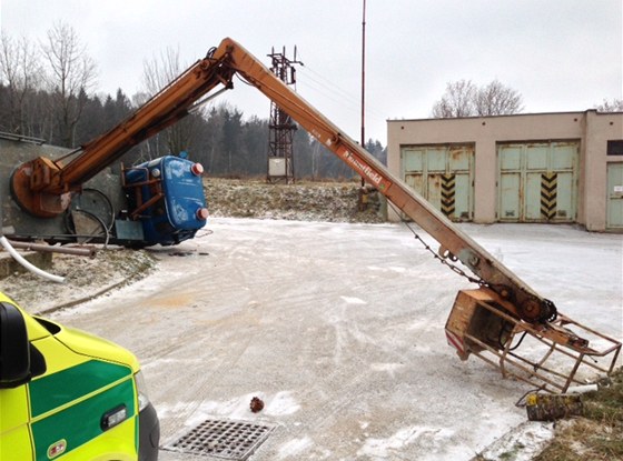 Pevrácené nákladní auto Avia s manipulaní ploinou v areálu firmy v obci