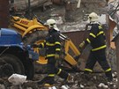 Hasiči ve Frenštátě pod Radhoštěm procházejí před ruinou domu zdemolovaného