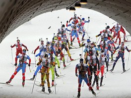 Z TUNELU. Biatlonisté na trati závodu na 15 km s hromadným startem.