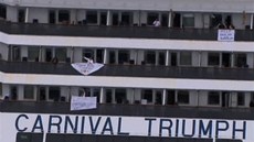 Lidé z lodi Carnival Triumph z oken veli transparenty.