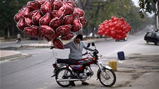 Mladík tla�í motocykl s valentýnskými balónky v pakistánském Islámábádu. (14.