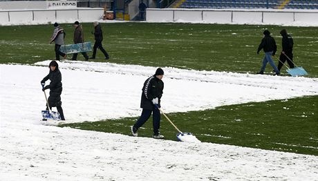 Na mnoha stadionech musely ped zápasem odklízet sníh.