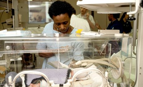 Zdravotní sestra oetuje novorozence v inkubátoru. 