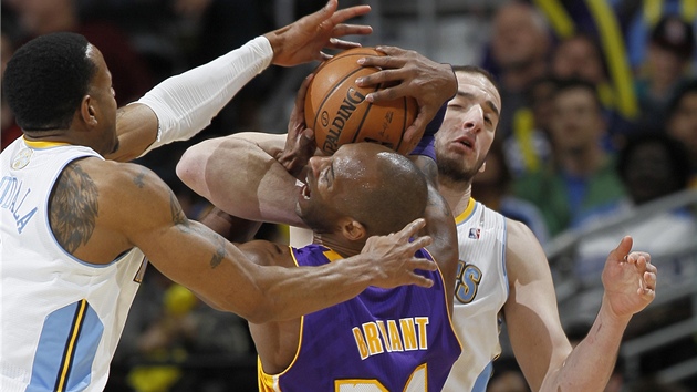 Hvzda LA Lakers Kobe Bryant poznv tvrdost hr Denveru. Vpravo ho zpracovv Kosta Koufos, vlevo mu pomh Andre Iguodala. 