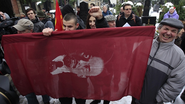 Mlad komunist na Olansk hbitovy pili i s vlajkami s Leninovou podobiznou nebo kladivem a srpem.
