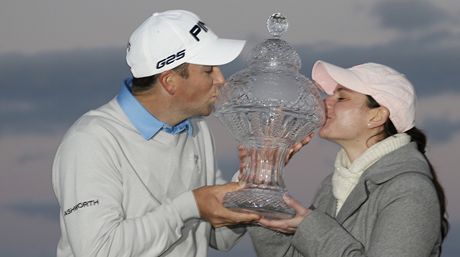 Americký golfista Michael Thompson se svou manelkou  Rachel líbají trofej pro