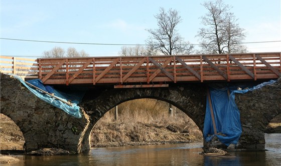 Historický most v Ronov nad Sázavou nyní slouí spí jan jako podpra pro provizorní devnou lávku. Zahájení oprav, které by mu mly vrátit pvodní podobu, brání spor dvou odbor jediného úadu.