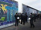 Policisté hlídají ást Berlínské zdi, kterou stavai bourali. 
