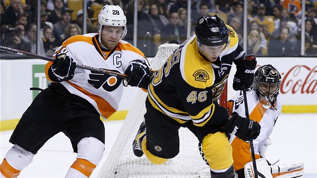 Claude Giroux z Philadelphie sth Davida Krejho z Bostonu.