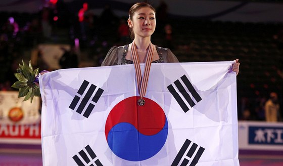 Kim Ju-na pózuje po svém triumfu s jihokorejskiu vlajkou.