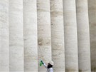 Pracovník istí sloupy Berniniho kolonády ve Vatikánu. (9. bezna 2013)