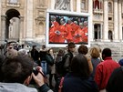 Lidé na námstí svatého Petra ve Vatikánu sledují penos z kardinálské