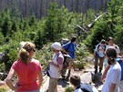 Turisté na stezce Trojmezenským pralesem pozorují, jak tu probíhá pírodní