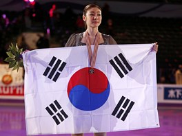Kim Ju-na pzuje po svm triumfu s jihokorejskiu vlajkou.