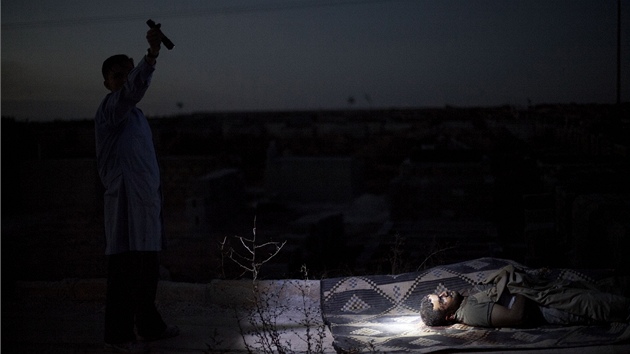 Syan osvtluje baterkou tlo mue zabitho bhem boj v Aleppu (jen 2012)