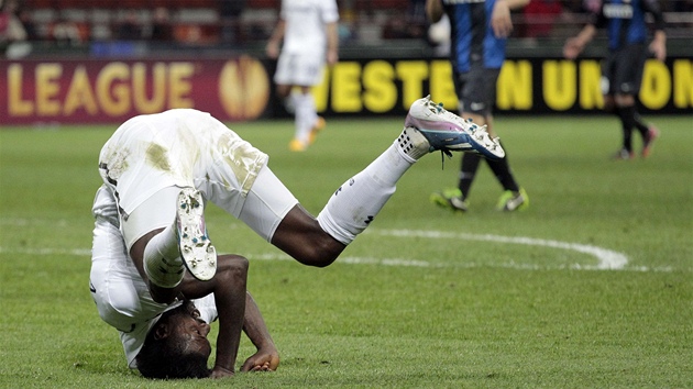 Útočník Emmanuel Adebayor z Tottenhamu krkolomně padá na trávník.