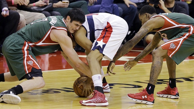 Ersan Ilyasova (vlevo) a Brandon Jennings (vpravo) z Milwaukee.bojuj o m s Garrettem Templem z Washingtonu.