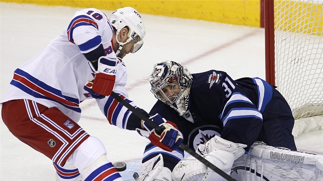 Ondej Pavelec, glman Winnipegu, zasahuje proti Marinu Gaborkovi z NY Rangers.