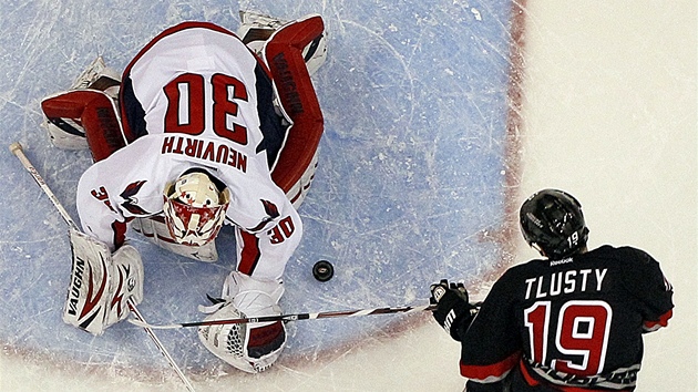 Michal Neuvirth z Washingtonu zasahuje proti dorce Jiho Tlusho z Caroliny.